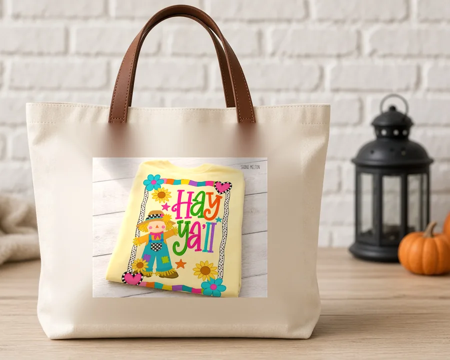 Hay Yall Harlequin Scarecrow PNG design on a canvas tote bag